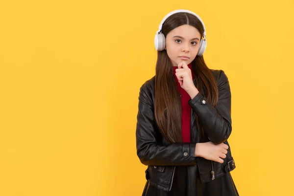 Thinking child in headphones on yellow background, e-learning — Photo