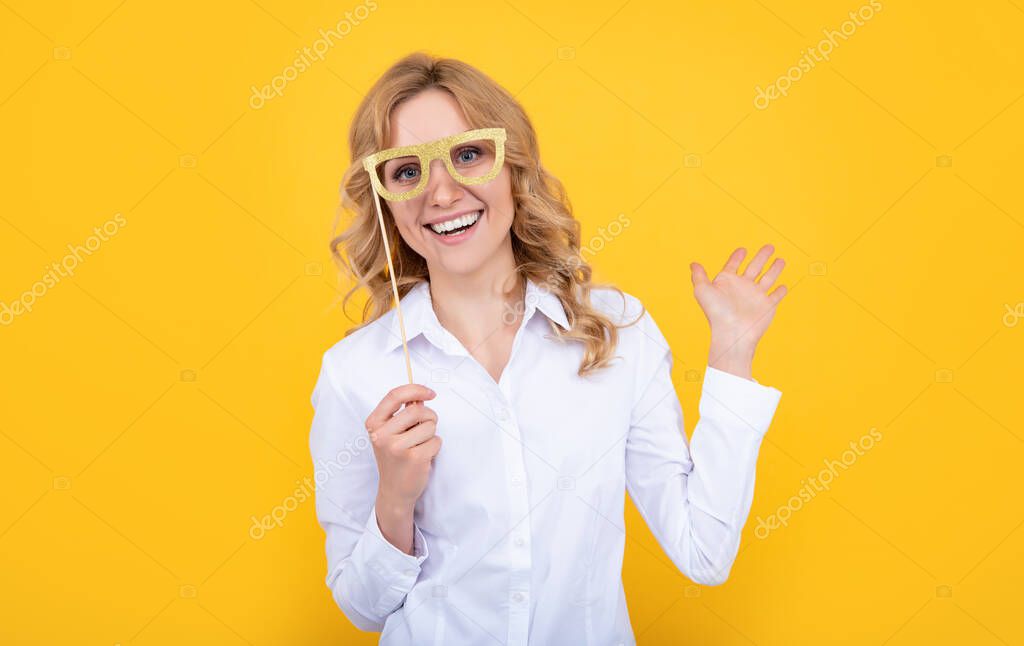 happy woman with funny party glasses on yellow background