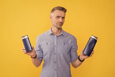 Adam şampuan şişesini ya da saç kremini seçiyor. Günlük alışkanlıklar ve kişisel bakım.