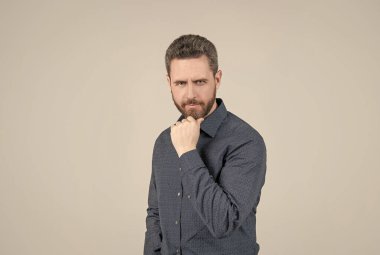 Sakal burada kalacak. Tıraşsız bir adam sakallı, gri arkaplana dokunur. Berberlik ve tımar.