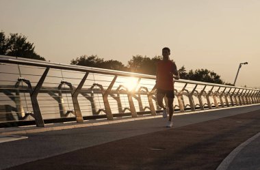 Akşam koşusu. Atletik adam gezinti güvertesinde koşuyor. Koşan adam. Akşam koşucusu. Koşu faaliyetleri