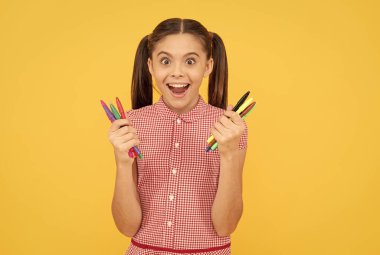 Şaşırmış genç kız renkli kalemler taşıyor. Resim için ofis malzemeleri, yaratıcı zihin.