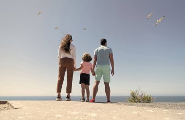 Anne, baba ve çocuğun ailesi gelecekte el ele tutuşacak. Yazın, arka planda, hayat sigortasında.