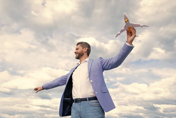 Szczęśliwy człowiek z zabawkowym samolotem. sukces biznesowy. odnoszący sukcesy mężczyzna w garniturze marzy. — Zdjęcie stockowe