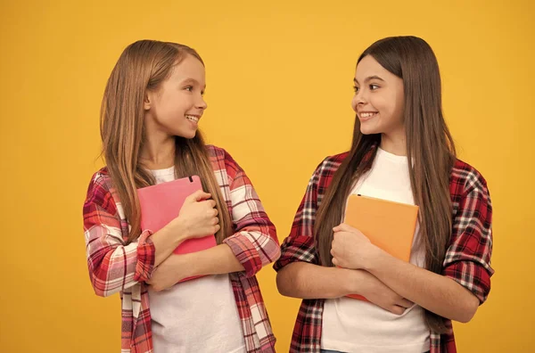 Щасливі дівчата-підлітки у випадковій картатій сорочці з блокнотами, сестринство — стокове фото