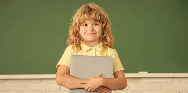 E-learning. enfant étudiant avec ordinateur. joyeux adolescent garçon dans la salle de classe. retour à l'école. — Photo