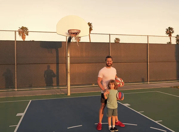 Feliz padre e hijo juegan baloncesto con pelota en el patio de recreo, fin de semana familiar — Foto de Stock