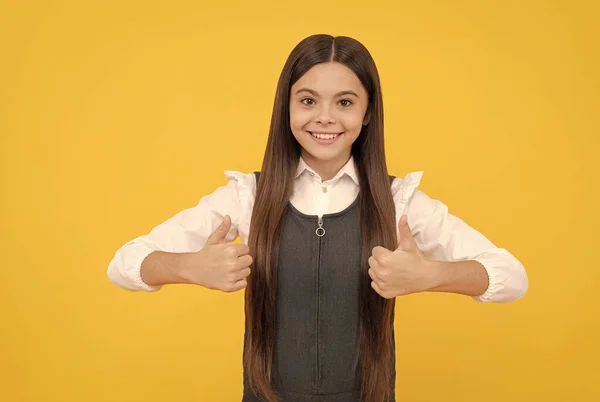 Glad flicka barn i skolan uniform leende visar dubbel tummen upp hand gest, tillfredsställelse — Stockfoto