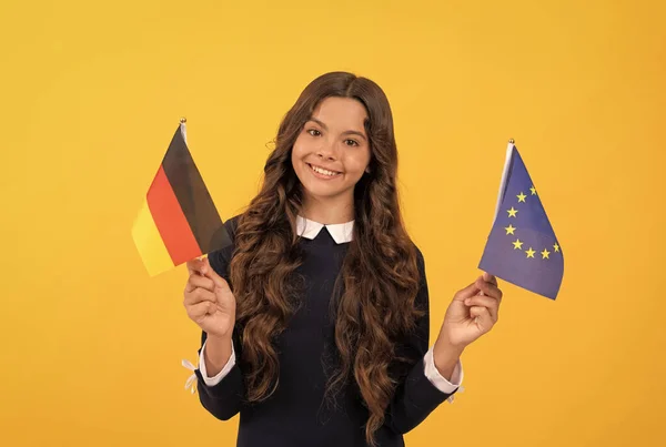 Οπαδός του ποδοσφαίρου. χαρούμενο παιδί που κρατά την Ευρωπαϊκή Ένωση και τη γερμανική σημαία. τουριστική θεώρηση — Φωτογραφία Αρχείου