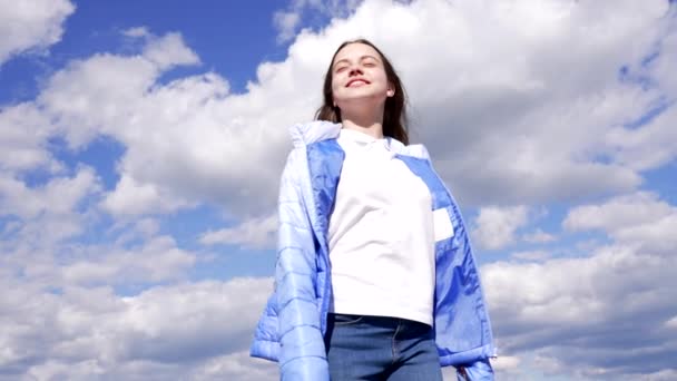 Χαρούμενο κορίτσι με φθινοπωρινό σακάκι απολαύστε τον ήλιο στο φόντο του ουρανού, επίτευγμα — Αρχείο Βίντεο