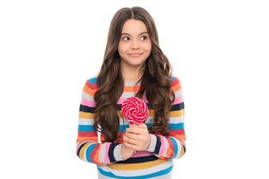 Süveter giymiş gülümseyen genç kız lolipop şekeriyle beyaz arka planda izole edilmiş çubuk şeker, şeker ikram.