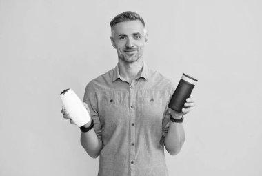 Adam şampuan şişesini ya da saç kremini seçiyor. Günlük alışkanlıklar ve kişisel bakım.