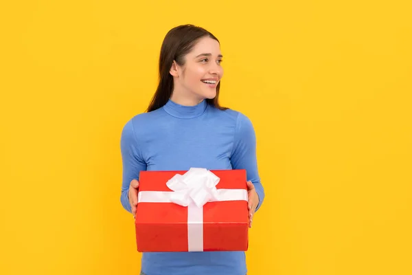 Szezonális értékesítés. mosolygós lány doboz sárga háttér. Boksz nap. ajándék és ajándék vásárlás — Stock Fotó