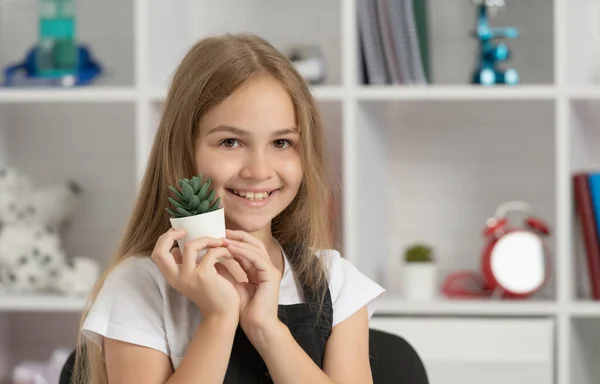 Glad child hold potted plant in school classroom — 스톡 사진