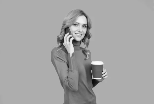 Сексуальна жінка говорить на мобільному телефоні, тримаючи гарячу чашку ароматного чаю або кавового напою, відпочинок — стокове фото