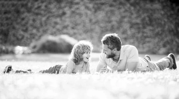 Feliz familia de papá e hijo niño relajarse en el parque de verano hierba verde, crianza de los hijos —  Fotos de Stock