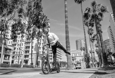 E-scoking her zamankinden daha iyi. Mutlu iş adamları e-posta atarken eğleniyor. Cadde boyunca e-scooter sürmek