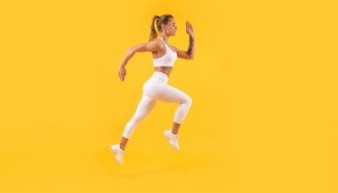 Sarı arka planda çalışan aktif fitness kadın koşucusu