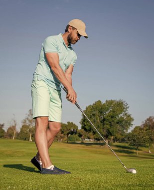 golfer in cap with golf club. people lifestyle. man playing game on green grass. summer activity