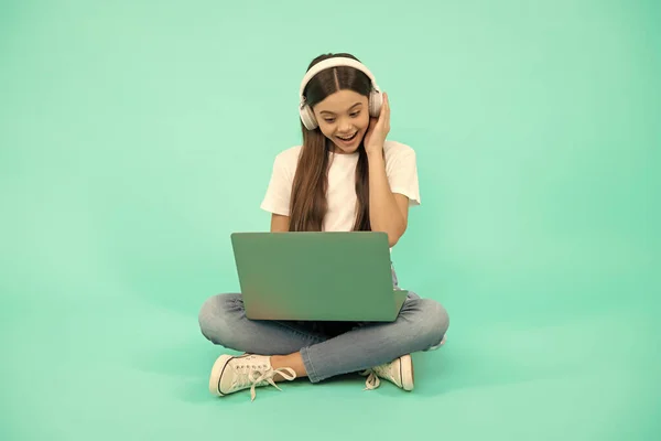 Menina criança surpresa usar computador sem fio para chamada de vídeo ou ouvir webinar em fones de ouvido, conversando — Fotografia de Stock