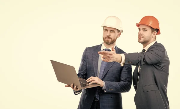 Два інженери в костюмі та захисному шоломі використовують ноутбук ізольований на білому копіювальному просторі, бізнес з безпеки — стокове фото