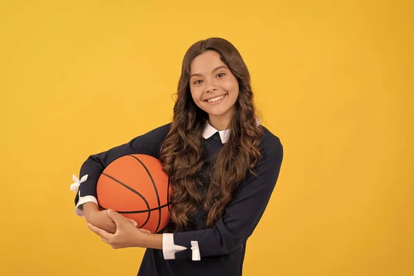 Sonriente niño mantenga pelota de baloncesto sobre fondo amarillo, baloncesto —  Fotos de Stock