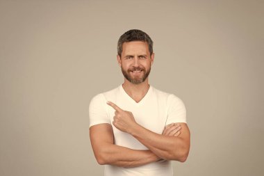 Mutlu yakışıklı adam gülümsüyor. Gri arka plan fotokopi alanını işaret ediyor.