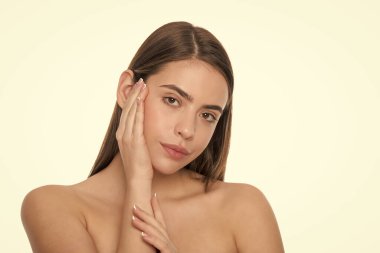 Cilt güzelliği. pürüzsüz ve yumuşak kadın teni. Kadın yüzüne dokunuyor. Çıplak omuzlu genç kız..