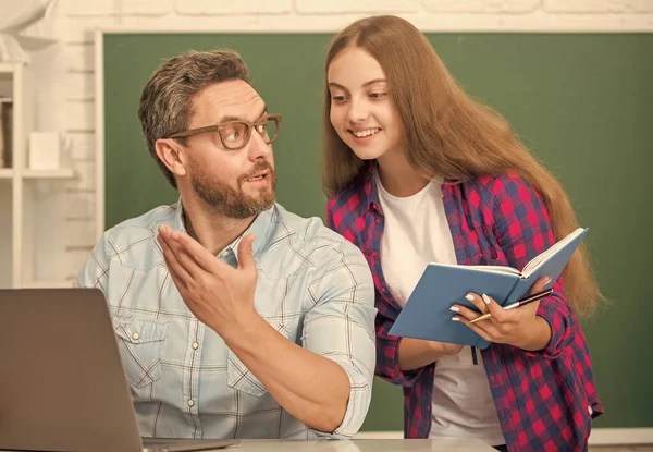 Childhood education. cheerful pupil and tutor with laptop. father and teen girl study. — Stockfoto