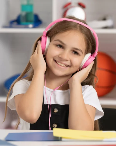 Niño contento escuchar música en auriculares en el aula de la escuela — Foto de Stock