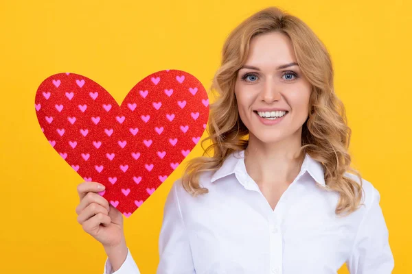 Happy woman with red love heart on yellow background. charity — Stock Fotó