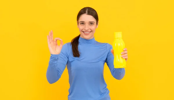 Happy young lady hold sport bottle with water with ok gesture, hydration — Stock fotografie