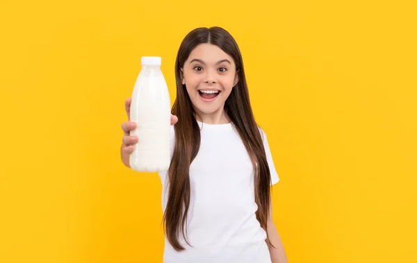 Hayretler içindeki çocuk süt ürünlerini elinde tutuyor. Kız süt içecek. sağlıklı yaşam tarzı. — Stok fotoğraf