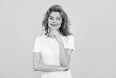 Güzel, kızıl saçlı, kıvırcık saçlı, gülümseyen ve kameraya gülen bir kızın portresi.