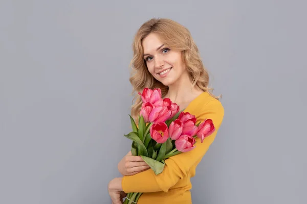 Laleli pozitif kadın. Bayan bahar tatili için çiçekleri saklar. Buketli kız — Stok fotoğraf