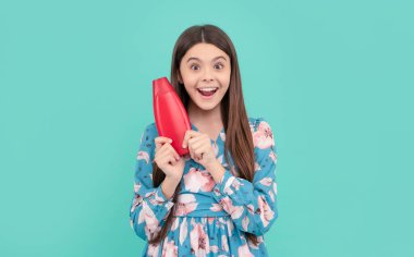 Şaşırmış uzun saçlı çocuk şampuan şişesi, cilt bakımı