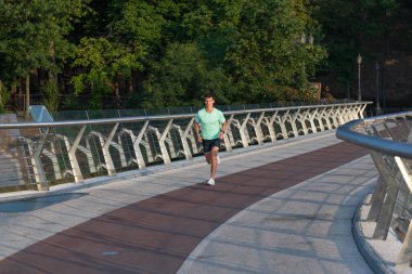 Spor giysileriyle koşan atletik bir koşucu.