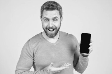 Sakallı mutlu adam akıllı telefon ve terfi gösteriyor.