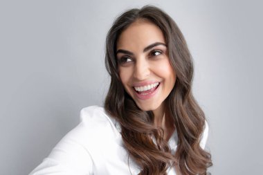 Close-up of young beautiful woman taking selfie. Isolated gray background. Portrait of cool cheerful girl having video-call, shooting selfie.