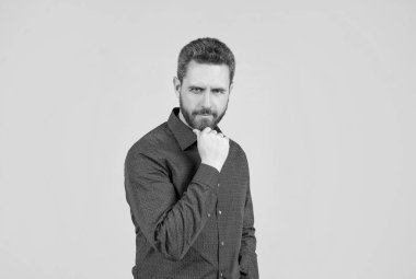 Sakal burada kalacak. Tıraşsız bir adam sakallı, gri arkaplana dokunur. Berberlik ve tımar.