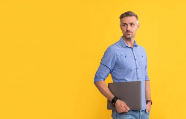 Olgun adam bilgisayarını sarı arkaplanda tut, kopyala alanı, işletme yöneticisi