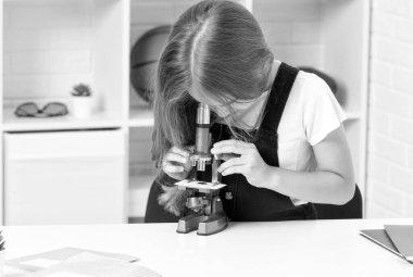 Gelecekteki bilim adamı çocuk dürbünden bakıyor. Bilimsel metodu kullan. bilim ve çocukluk.