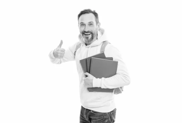 Счастливый человек носить рюкзак держать блокнот или рабочую тетрадь для образования изолированы на белом, большой палец вверх. — стоковое фото