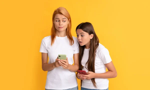 Mother and daughter typing and texting. sms and instant messaging. mom and kid bloggers —  Fotos de Stock