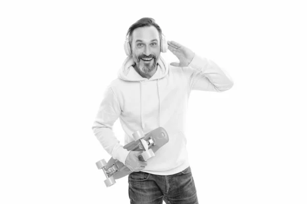 Smiling senior guy listen music isolated on white. man in yellow hoody with skateboard. — Photo