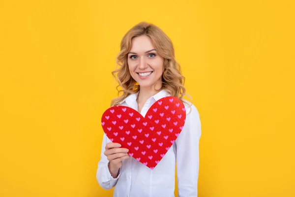 Χαμογελαστή γυναίκα με κόκκινη καρδιά αγάπης σε κίτρινο φόντο — Φωτογραφία Αρχείου