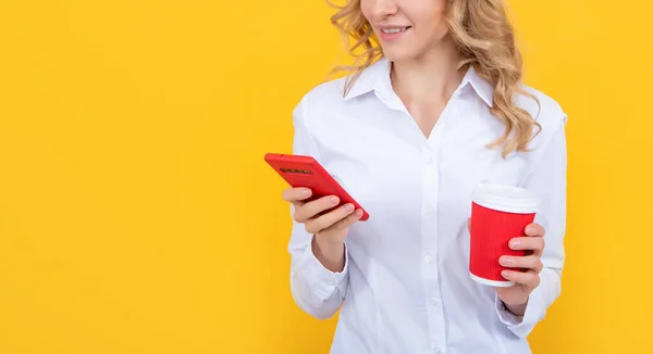 Glad blond kvinna med kaffekopp chatta på telefon på gul bakgrund — Stockfoto