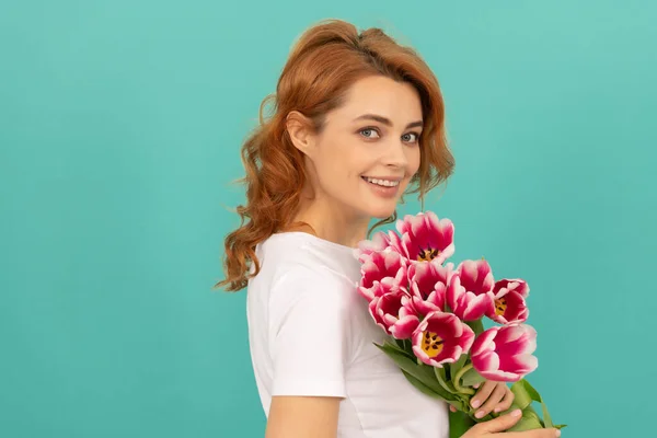 Mavi arka planda lale çiçeği buketi olan mutlu kız portresi — Stok fotoğraf