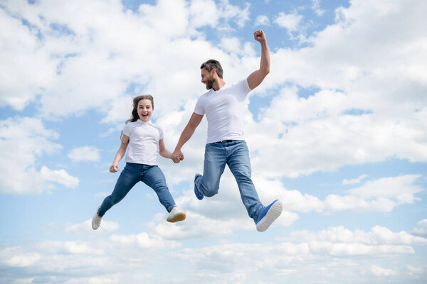 happy father and daughter jump in sky