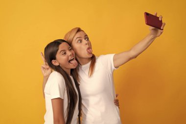 Komik kadın ve kız cep telefonuyla selfie çekiyorlar. Selfie ailesi. Modern hayat. mobil teknoloji